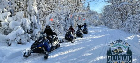 Four snowmobilers enjoying a day out in the Green Mountains