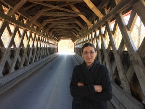 MaryAnn standing and road way on the inse of wooden bridge.