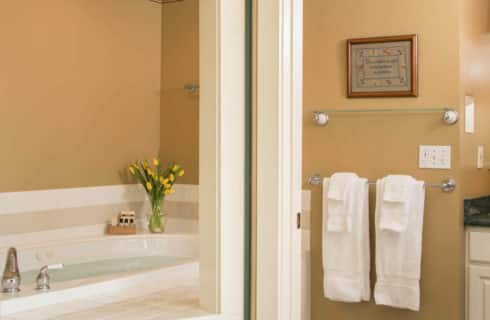 Bright and clean bathroom with a large soaking tub and a cabinet sink in white.