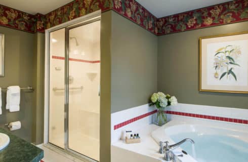 Big bathroom with a large soaking tub, a shower enclosure and a vanity with a green countertop.